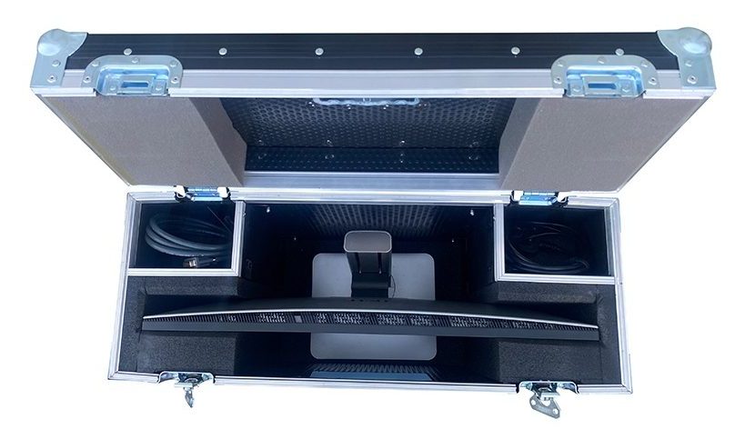 Open aluminum flight case with a curved computer monitor secured in foam inserts for transport.