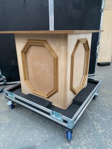 Wooden cabinet on a wheeled road case with two octagonal framed insets on the front panel