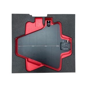 Gray metal panel secured in red foam protective packaging inside a foam case, viewed from above.